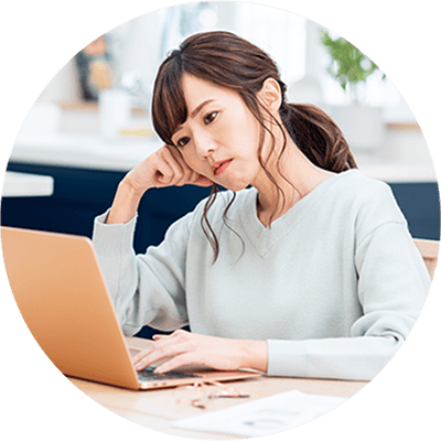 パソコンの前で考えこむ女性